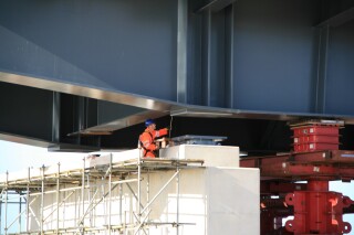 Final checks and measurements are made before the section is lowered