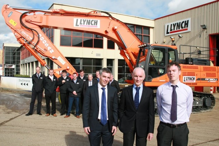 The photo shows one of the new excavators (a DX380) with, in the foreground from left to right, Robert, Liam and Merrill Lynch. Behind them are members of the Lynch sales team.