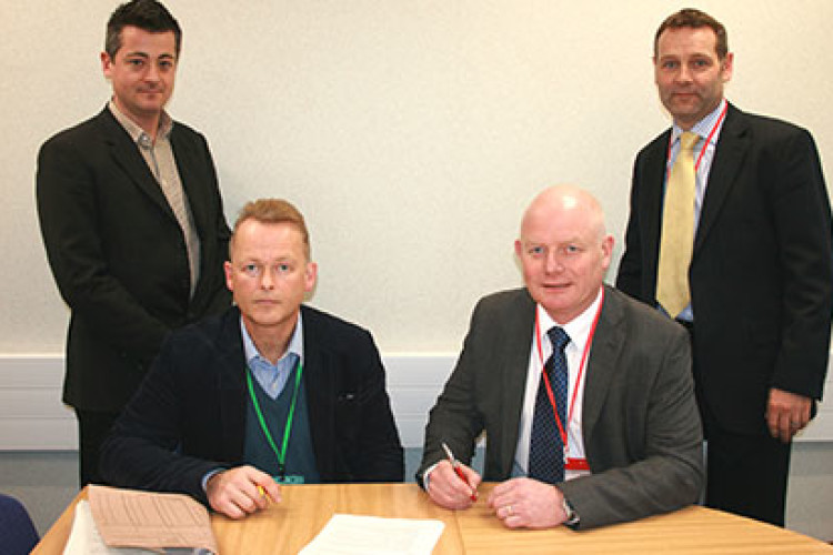 Seated are David Stacey of DIO (left) and John Leary of Lovell, signing the contract; standing behind are Stuart Gallacher of DIO (left) and David Gough of Lovell