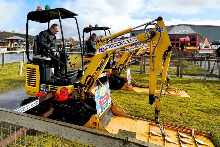 Ed Davey knocks down skittles with a mini digger