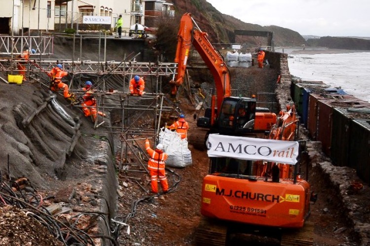 At Dawlish, on Devon's south coast, shipping containers have been welded together to make a temporary sea wall, allowing contractors to begin railway repairs