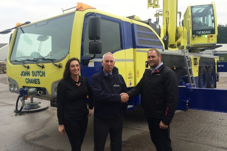 Terex regional sales manager Tim Leech (right) hands over the crane to the father and daughter management team, John and Hayley Sutch